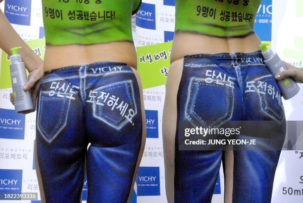 Western models display a body painting made to look like blue jeans at a shopping district in Seoul, 03 April 2007, as part of a publicity campaign...