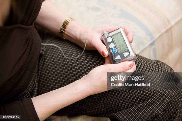 holding insulin pump - insulin pump stock pictures, royalty-free photos & images