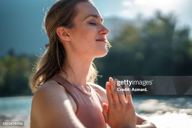 kaukasische frau meditiert in yoga-sitzung an der soča - bildtechnik stock-fotos und bilder