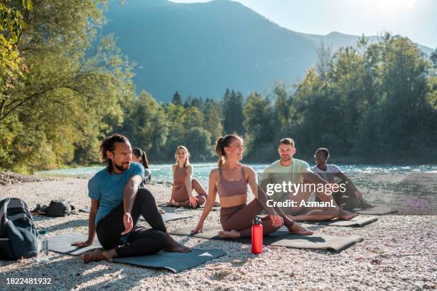 multicultural yoga mats by the water - bank of slovenia stock pictures, royalty-free photos & images