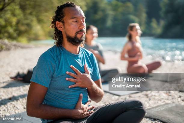 männer meditieren in yoga-sitzungen im freien - atemübung yoga 30 bis 40 jahre stock-fotos und bilder