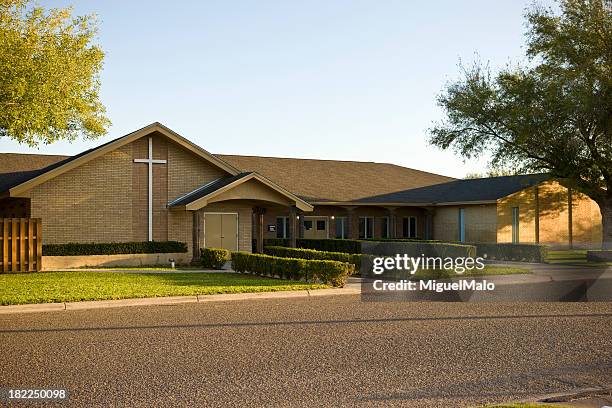 long view of the front of a brown brick church with a cross - kork stock pictures, royalty-free photos & images