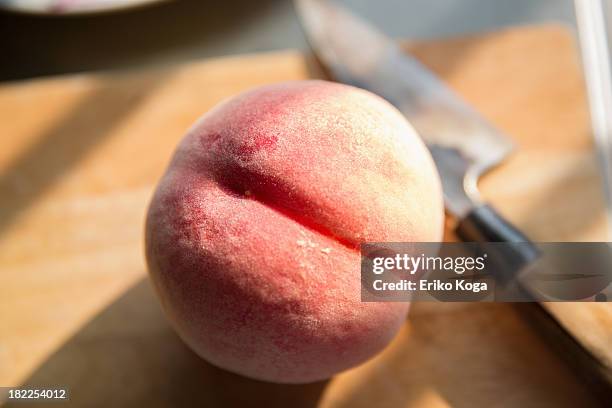 peach on cutting board with kitchen knife - もも ストックフォトと画像