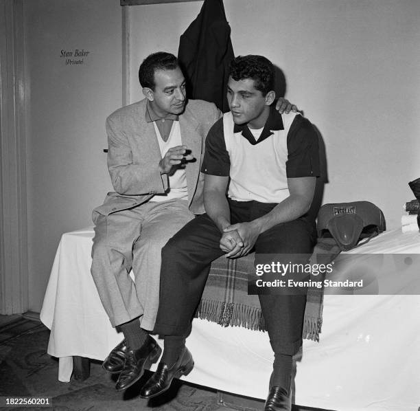 American boxing trainer Angelo Dundee , left, gives advice to boxer Willie Pastrano , while both are seated on a bed, London, October 21st 1957....