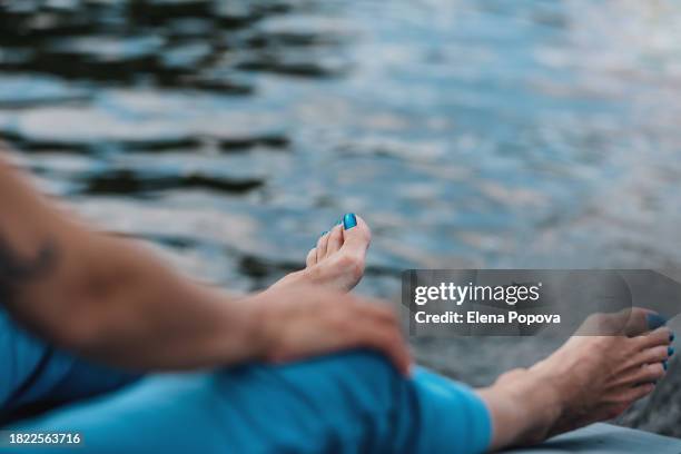 low section barefoot woman with bunions traveling by motorboat and having relax time - bunion stock-fotos und bilder