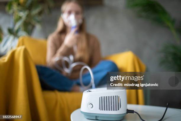 girl using a portable nebulizer at home - nebulizer stock pictures, royalty-free photos & images