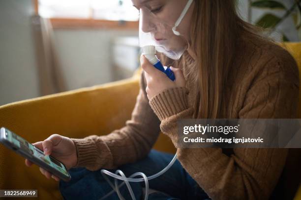 girl using a portable nebulizer at home - breathing problems stock pictures, royalty-free photos & images