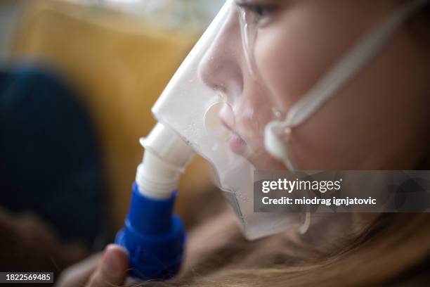 girl using a portable nebulizer at home - nebulizer stock pictures, royalty-free photos & images