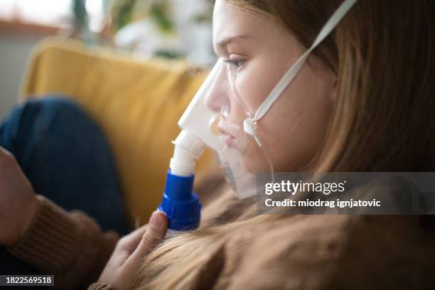 girl using a portable nebulizer at home - nebulizer stock pictures, royalty-free photos & images