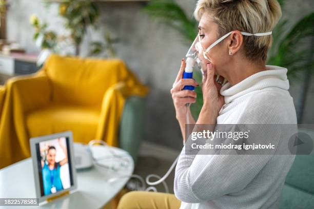 woman watching an online medical tutorial at home - respiratory infection stockfoto's en -beelden