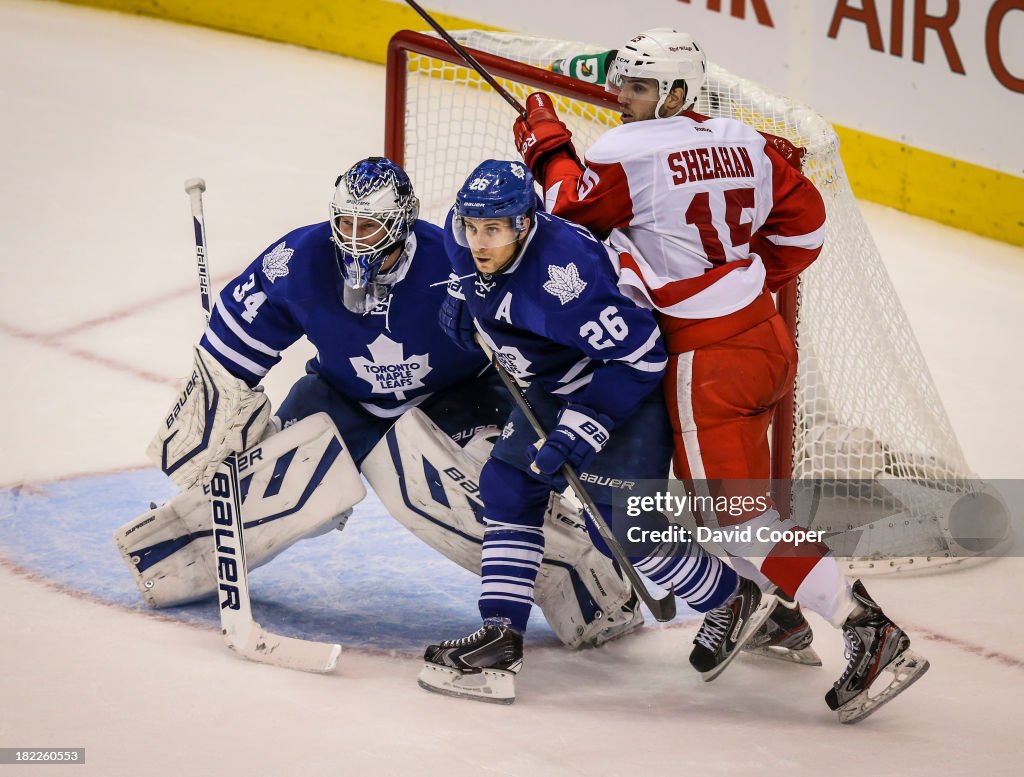 Toronto Maple Leafs defenseman John-Michael Liles (26) tries to clear Detroit Red Wings center Riley Sheahan (15) from in front of Toronto Maple Leafs goalie James Reimer (34) as the Leafs beat the Red Wings 3-1