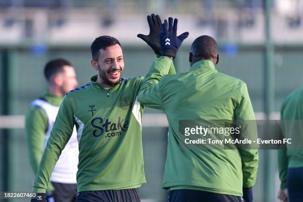 Dwight McNeil and Abdoulaye Doucoure high five during the Everton Training Session at Finch Farm on November 28, 2023 in Halewood, England.