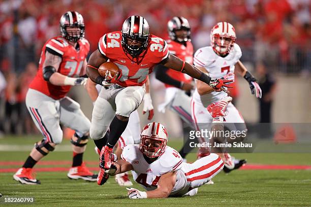 Carlos Hyde of the Ohio State Buckeyes leaps to avoid a tackle by Chris Borland of the Wisconsin Badgers in the first quarter at Ohio Stadium on...