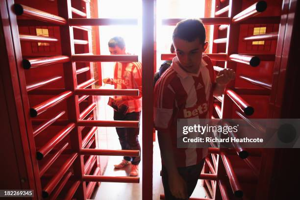 Supporters enter the ground through the turnstiles prior to the Barclays Premier League match between Stoke City and Norwich City at the Britannia...