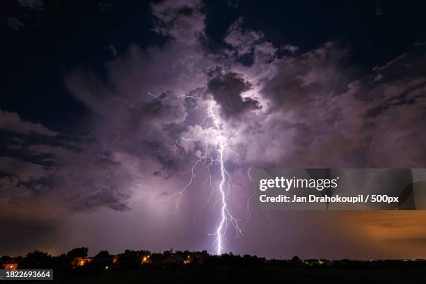 low angle view of lightning in sky at night - temporale foto e immagini stock