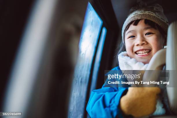lovely cheerful girl in beanie hat smiling joyfully while travelling in a car - auto mieten stock pictures, royalty-free photos & images