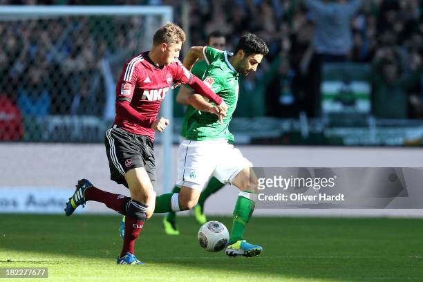 Mehmet Ekici of Bremen and Niklas Strak of Nuernberg compete for the ball during the First Bundesliga match between SV Werder Bremen and 1.FC...