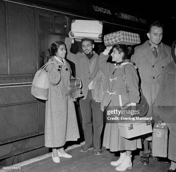 Israeli dancers Margalit Oved, Moshe Ariel and Esther Drif of the Inbal Dance Theatre, hold luggage on their heads on a platform after arriving at...