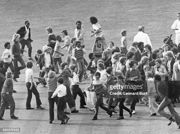 Spectators invade the pitch after West Indies batsman Clive Lloyd made a century on the first day of the 1st Test against England at the Oval cricket...