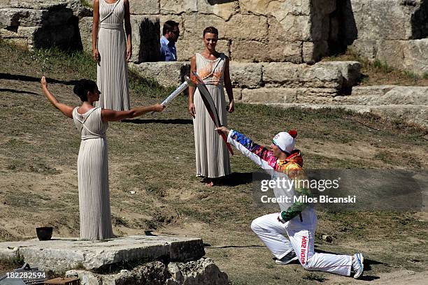 High Priest Ino Menegaki lights the torch of a torchbearer during the lighting ceremony of the Olympic Flame for the Sochi 2014 Winter Olympic Games...