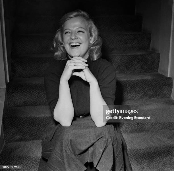 American actress Kim Stanley laughs while seated on stairs, January 2nd 1958.