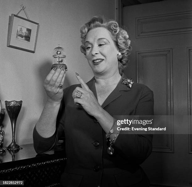 British actress Brenda de Banzie holding a miniature birdcage, January 15th 1958.