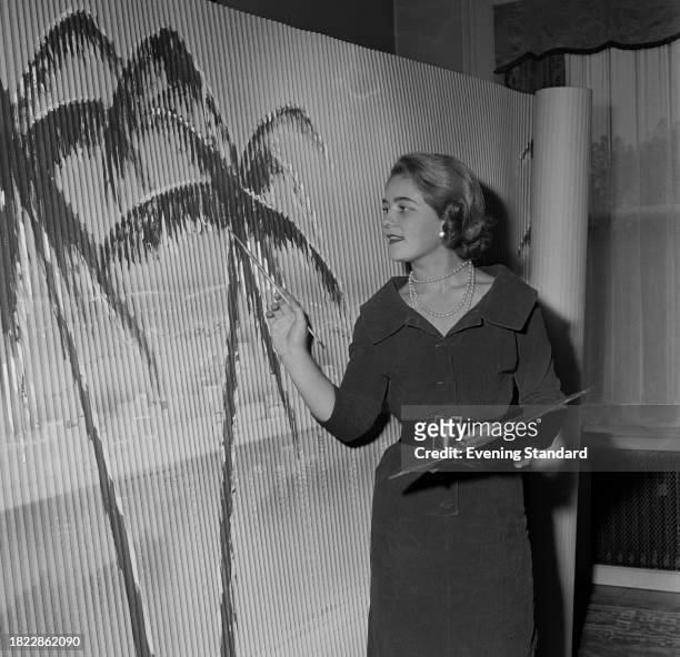 Artist Angela Huth painting palm trees on a large roll of paper, October 1st 1957.