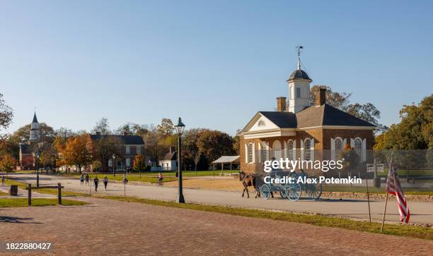 un carruaje tirado por caballos pasa frente al palacio de justicia en el sitio histórico de la colonia williamsburg, virginia - episcopalismo fotografías e imágenes de stock