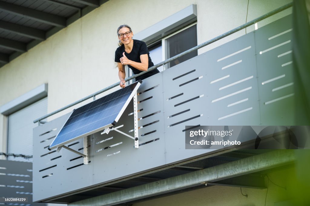Woman happy after installing solar panel on balcony