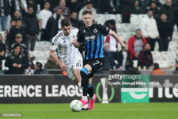 Andreas Skov Olsen of Club Brugge runs with the ball under pressure from Amir Hadziahmetovic of Besiktas during the UEFA Europa Conference League...
