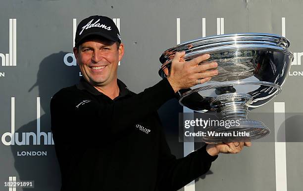 David Howell of England lifts the trophy aloft after victory at the Alfred Dunhill Links Championship on The Old Course, at St Andrews on September...