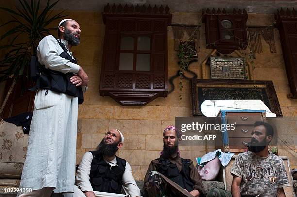 Picture dated September 18, 2013 shows Abu Mohammed , a Sunni Muslim imam from the Liwa al-Tawhid rebel group, talking to his comrades about religion...