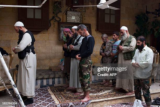 Picture dated September 18, 2013 shows Abu Mohammed , a Sunni Muslim imam from the Liwa al-Tawhid rebel group, leading a prayer with his comrades in...