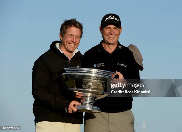 David Howell of England celebrates with his playing partner Hugh Grant on the Swilken Bridge on the 18th hole after victory at the Alfred Dunhill...