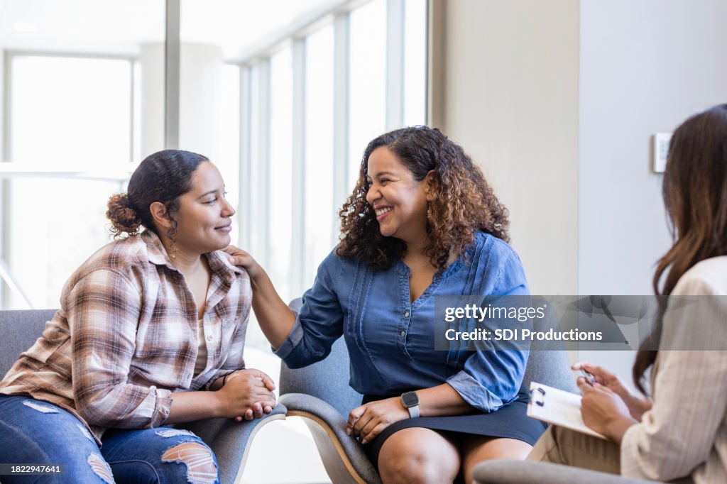Mother smiles proudly at her daughter after telling the therapist how much she loves her