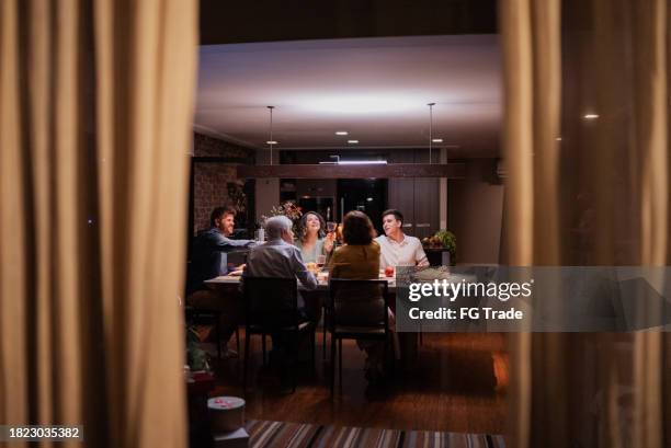 family on celebratory toast at christmas dinner - family dinner stock pictures, royalty-free photos & images