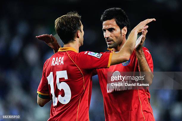 Rafael Lopez and his team-mate Juan Rodriguez of Getafe CF celebrate after defeating RCD Espanyol at the end of the La Liga match between RCD...