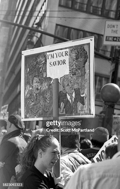 Demonstrator holds a sign during an anti-Iraq War protest on Broadway in Times Square, New York, New York, March 22, 2003. The sign features a...