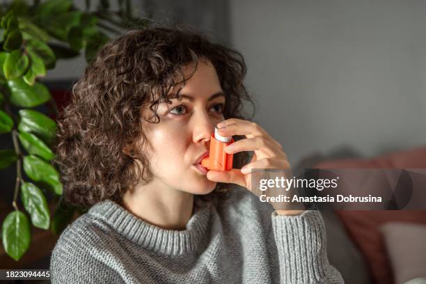 woman with asthma inhaler - reliever asthma inhaler stock pictures, royalty-free photos & images