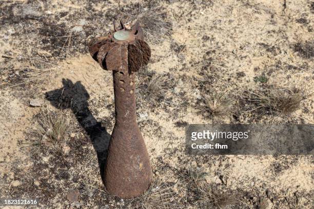 rusty shell stuck in the ground - rocket munition stock pictures, royalty-free photos & images