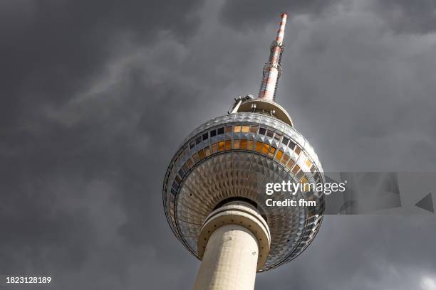 television tower berlin with dark clouds in the sky (fernsehturm, germany) - berliner fernsehturm stock-fotos und bilder