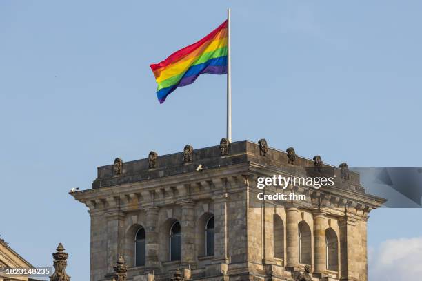 one tower of the deutsche bundestag - the reichstag building with and rainbow/ lgbtq+ - flag (german parliament building) - berlin, germany - berlin gay pride stock pictures, royalty-free photos & images
