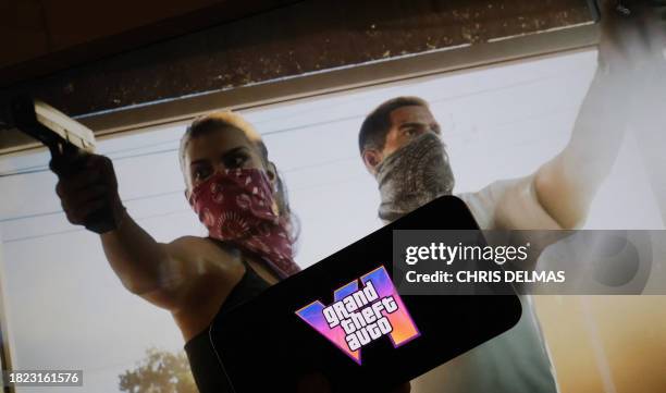 This illustration photo created in Los Angeles, December 4 shows Rockstar Games' Grand Theft Auto VI trailer played on a screen in front of the game...