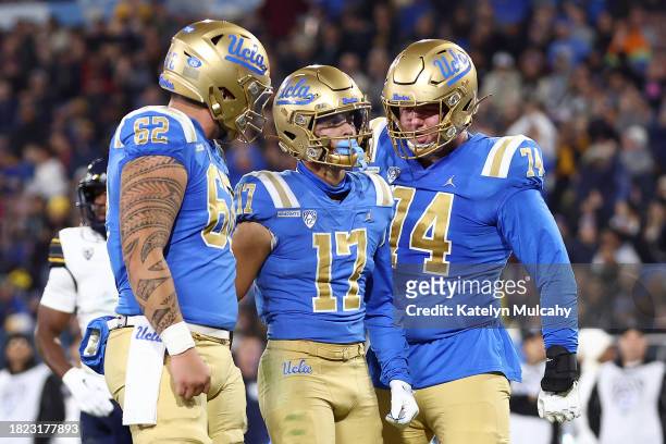 Logan Loya of the UCLA Bruins celebrates his touchdown with teammates Duke Clemens and Spencer Holstege during the second quarter against the...