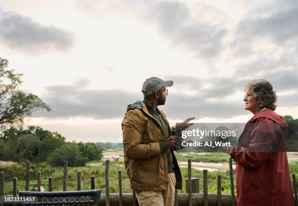 guide and a women talking on an observation deck in a wildlife reserve - indian tour guide stock pictures, royalty-free photos & images
