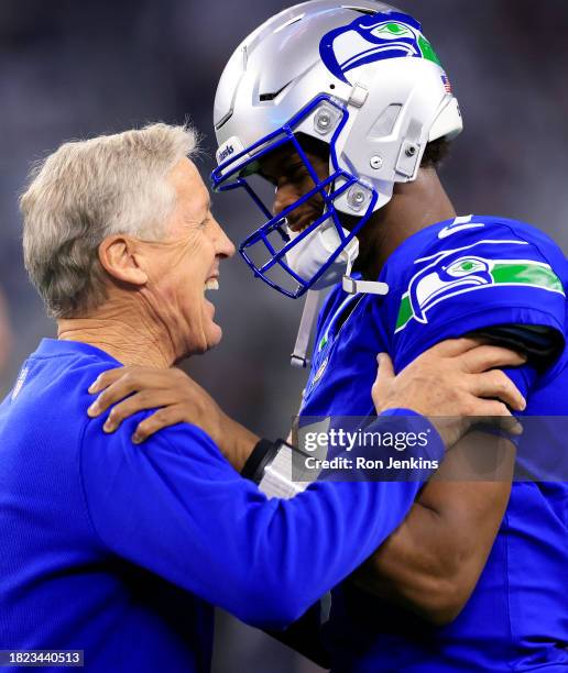 Quarterback Geno Smith of the Seattle Seahawks talks with head coach Pete Carroll prior to the game against the Dallas Cowboys at AT&T Stadium on...