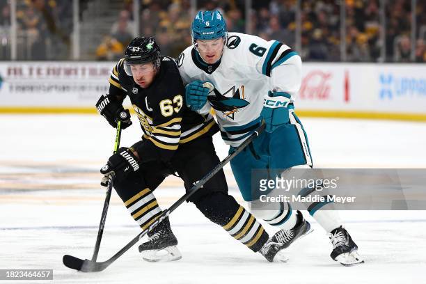 Brad Marchand of the Boston Bruins and Ty Emberson of the San Jose Sharks battle for control of the puck during the first period at TD Garden on...