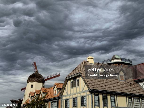 Unusual asperitas clouds, created by a strong jetstream rushing overhead and hitting the nearby mountains, above a tranquil Danish tourist town as...