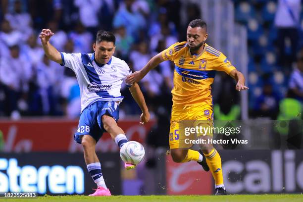 Martin Barragan of Puebla battles for possession with Rafael De Souza of Tigres during the quarterfinals first leg match between Puebla and Tigres...