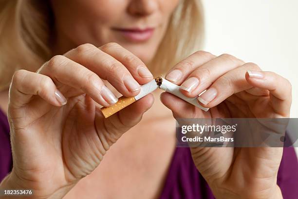 arrêter de fumer, brisant une cigarette - smoking cigarette photos et images de collection